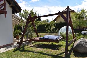 a wooden bed in a yard next to a house at #MazuryLove in Giżycko