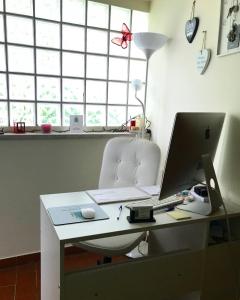 a white desk with a computer and a chair at Treviso Rooms in Treviso