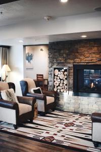 a living room with couches and a stone fireplace at 1872 Inn - Adults Exclusive in West Yellowstone