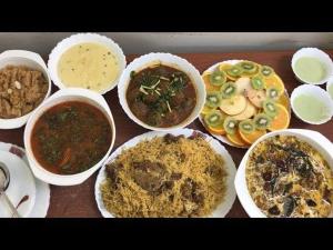 een tafel met kommen van verschillende soorten voedsel bij Diplomat Inn Hotel in Karachi