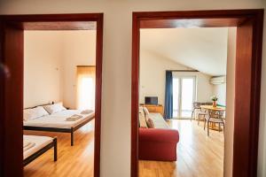 sala de estar con sofá y cama en una habitación en Family Apartments Mont Budva, en Budva