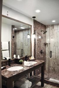 a bathroom with two sinks and a large mirror at 1872 Inn - Adults Exclusive in West Yellowstone