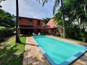 - une piscine en face d'une maison dans l'établissement Casa pé na areia em Toque Toque, à São Sebastião