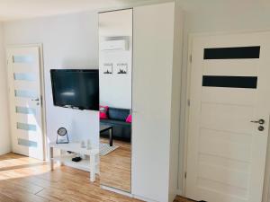 een woonkamer met een spiegel en een tv bij Apartament Poznańska24 in Bydgoszcz