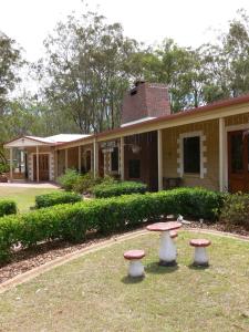 a building with three stools in front of it at Copper Country Motor Inn in Nanango