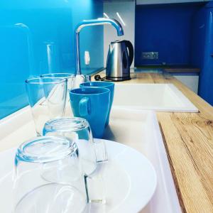 a kitchen counter with glasses and a sink at Bluemarine Apartment in Sofia