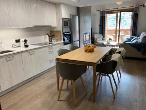 a kitchen and living room with a wooden table and chairs at Tuca del Mont in Benasque