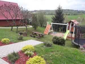 a park with a playground with a bench and a swing at Domki WiliCamp in Polańczyk