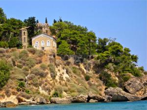 an old house on a hill next to the water at Mairoula apartments! in Koroni