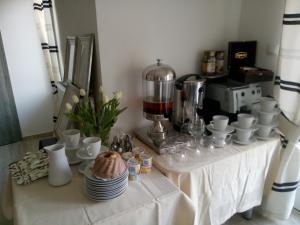 a table with cups and plates and a coffee maker at Villa Mors in Mielno
