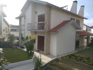 ein weißes Haus mit Balkon und Garten in der Unterkunft Casa da Piedade, Vouzela in Vouzela