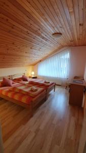 a large bedroom with two beds and a wooden ceiling at Apartmani Vila Danica in Soko Banja