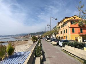 a sidewalk next to a beach with buildings and cars at Casa Nanà in Santo Stefano al Mare