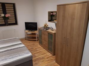 a bedroom with a large wooden cabinet and a television at Ferienhaus Ixheim Bitscher Str.70 in Zweibrücken