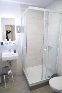 y baño con ducha y lavamanos. en Pension & Restaurant La Amalia en Bad Sauerbrunn