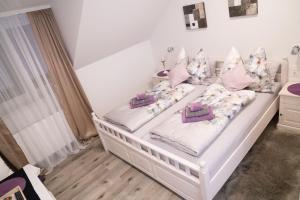 1 cama blanca con almohadas en el dormitorio en Pension & Restaurant La Amalia en Bad Sauerbrunn