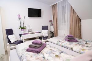 Habitación con 2 camas, mesa y escritorio. en Pension & Restaurant La Amalia en Bad Sauerbrunn