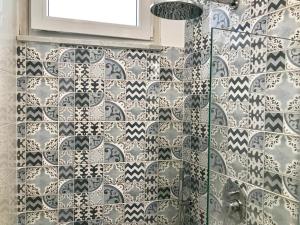 un bagno con una parete piastrellata in bianco e nero di Trifoglio Apartment a Maiori Altre 26 foto