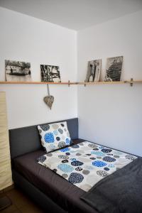 łóżko w pokoju z zdjęciami na ścianie w obiekcie Borálom Stúdió Apartman Tokaj w Tokaju