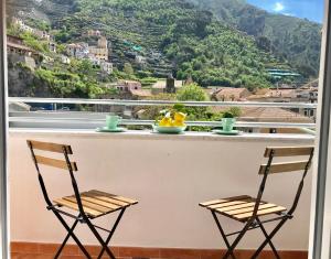 two chairs on a balcony with a view of a mountain at Trifoglio Apartment in Maiori