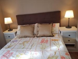 a bedroom with a bed with two nightstands and two lamps at Casita Las Melosillas in Casabermeja