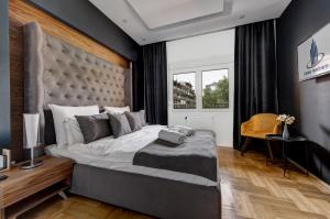 a bedroom with a large bed with a large headboard at CENTAR President in Arandjelovac