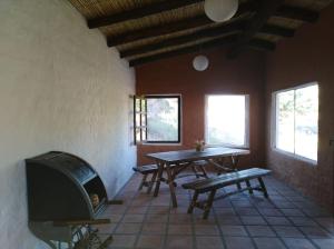 a living room with a table and a fireplace at Finca El Carmen Cabañas in Angastaco