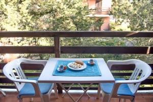 a table with chairs and a plate of food on a balcony at Casa Fabio in Stintino