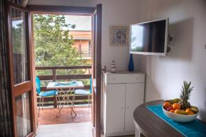 a kitchen with a balcony with a table and a television at Casa Fabio in Stintino