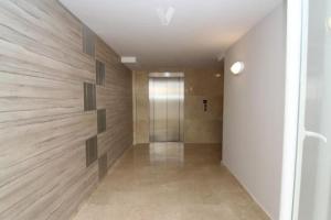 a hallway with wooden walls and a glass door at PRECIOSO APARTAMENTO PLAYA DE PILES in Piles