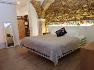 1 dormitorio con 1 cama con pared de piedra en Olhao Citycentre Apartment, en Olhão