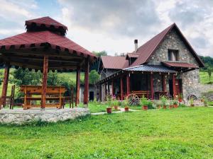 a building with a gazebo in a field at Guesthouse Alpini in Lëpushë