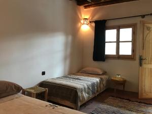 a bedroom with two beds and a window at Amlougui House in Marrakesh