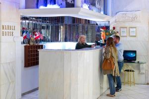 a group of people standing at a bar at Marble House in Athens