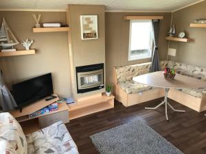 sala de estar con mesa y chimenea en Rockley Park - Coral, en Poole