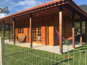 a cabin with a fence in front of it at Caminhos da Serra do Tabuleiro - Chalé Araucária in São Bonifácio