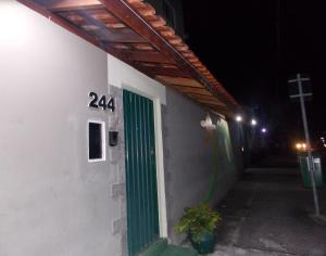 a green door on the side of a building at night at Hostel São José Dos Campos in São José dos Campos