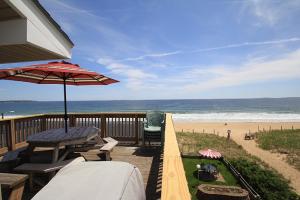 une terrasse avec une table et un parasol et la plage dans l'établissement The Skylark Beach Inn, à Old Orchard Beach