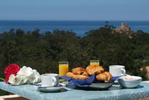 ポルトにあるCapo D'orto - Porto - Corseのクロワッサンとオレンジジュースの朝食付きのテーブル