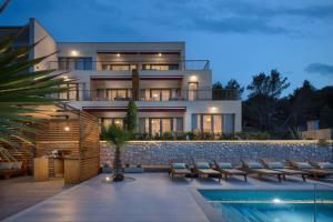 a villa with a swimming pool at night at Olive Hill House - ground floor in Slatine