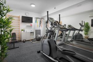 a gym with treadmills and exercise bikes in a room at Olive Hill House - ground floor in Slatine