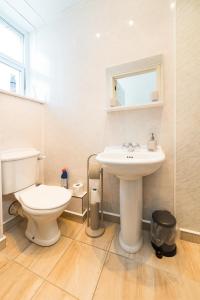 a white bathroom with a toilet and a sink at STAG City Centre apartment in Inverness