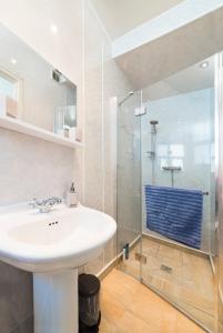 uma casa de banho com um lavatório e um chuveiro em STAG City Centre apartment em Inverness