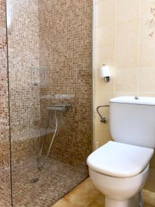 a bathroom with a toilet and a glass shower at Apartament amb jardi a la platja d'Empuriabrava in Empuriabrava +27 photos