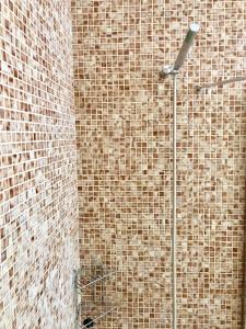 a bathroom with a brick wall with a shower at Apartament amb jardi a la platja d'Empuriabrava in Empuriabrava