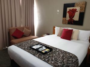 a hotel room with two beds and a chair at Best Western Endeavour Motel in Maitland