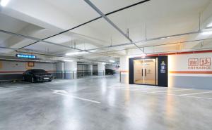 een lege parkeergarage met een auto erin geparkeerd bij Hotel Mfelice in Seoul