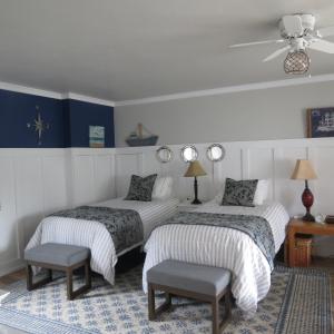 two beds in a room with blue and white walls at Tanbark Shores Guest Suite in Brookings