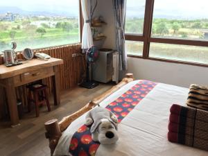 a dog laying on a bed in a bedroom at Beautiful Yilan Resort in Dongshan