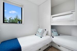 two beds in a small room with a window at Maunga View in Queenstown